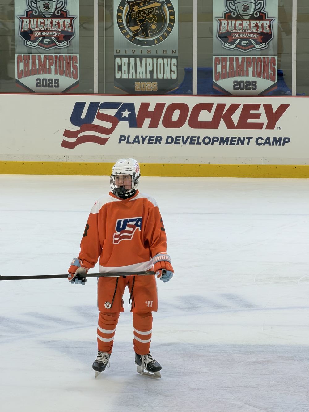 Cameron Cadena on the ice in front of the USA Hockey Player Development Camp boards at Miami University