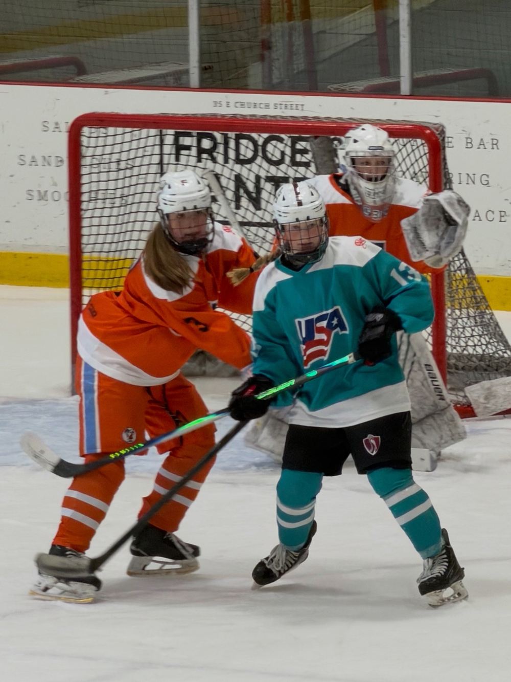 Cameron Cadena boxing out an opposing forward in front of the net at the Girls National 15 Camp